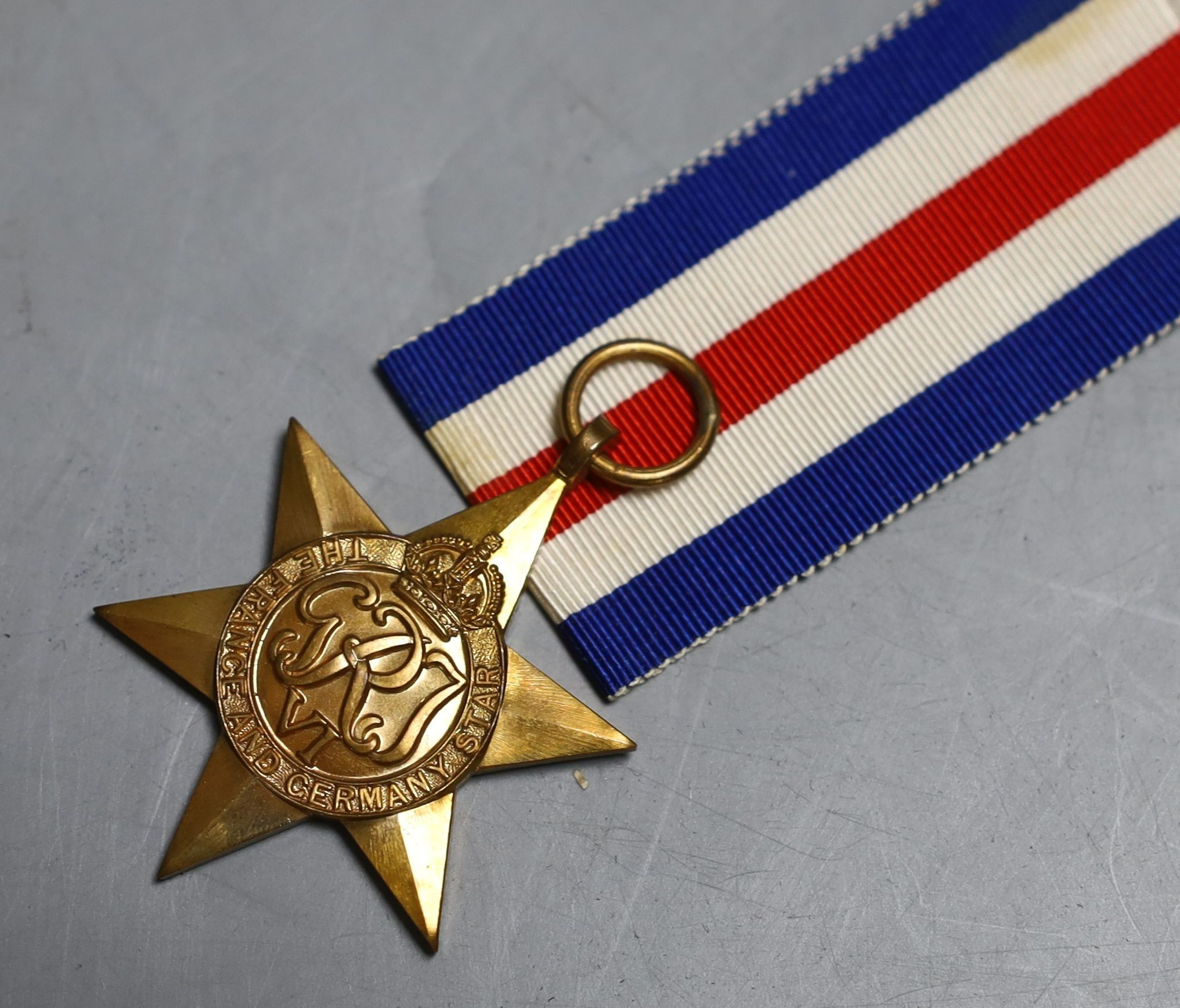 A group of five WW2 medals, together with a selection of cap badges and a GS Mk.II pocket watch